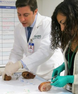 Dr.Vitale practicing surgical suturing with a Mini-Med student.